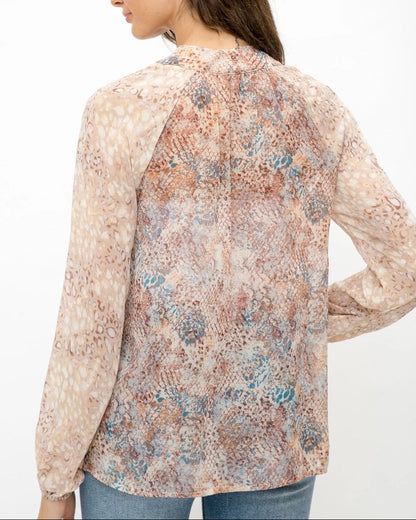 Mixed animal print patterned semi-sheer long sleeve blouse with a V-neckline and tie front. 