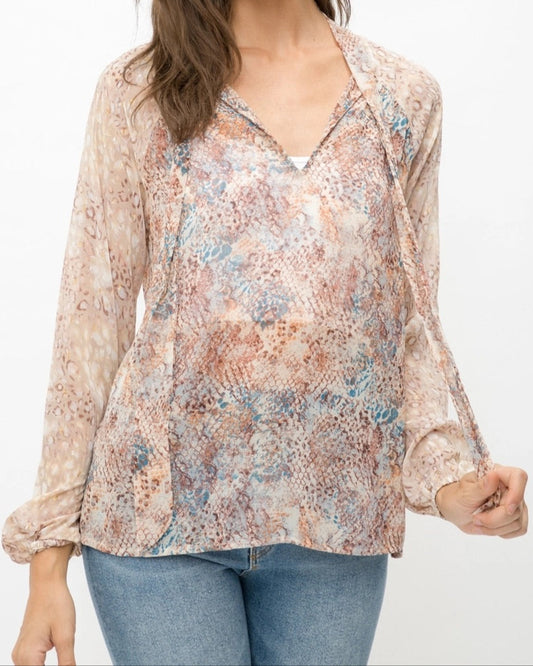 Mixed animal print patterned semi-sheer long sleeve blouse with a V-neckline and tie front. 