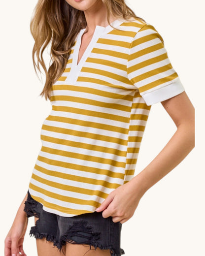 Woman wearing a yellow and white striped shirt with black shorts on a white background.