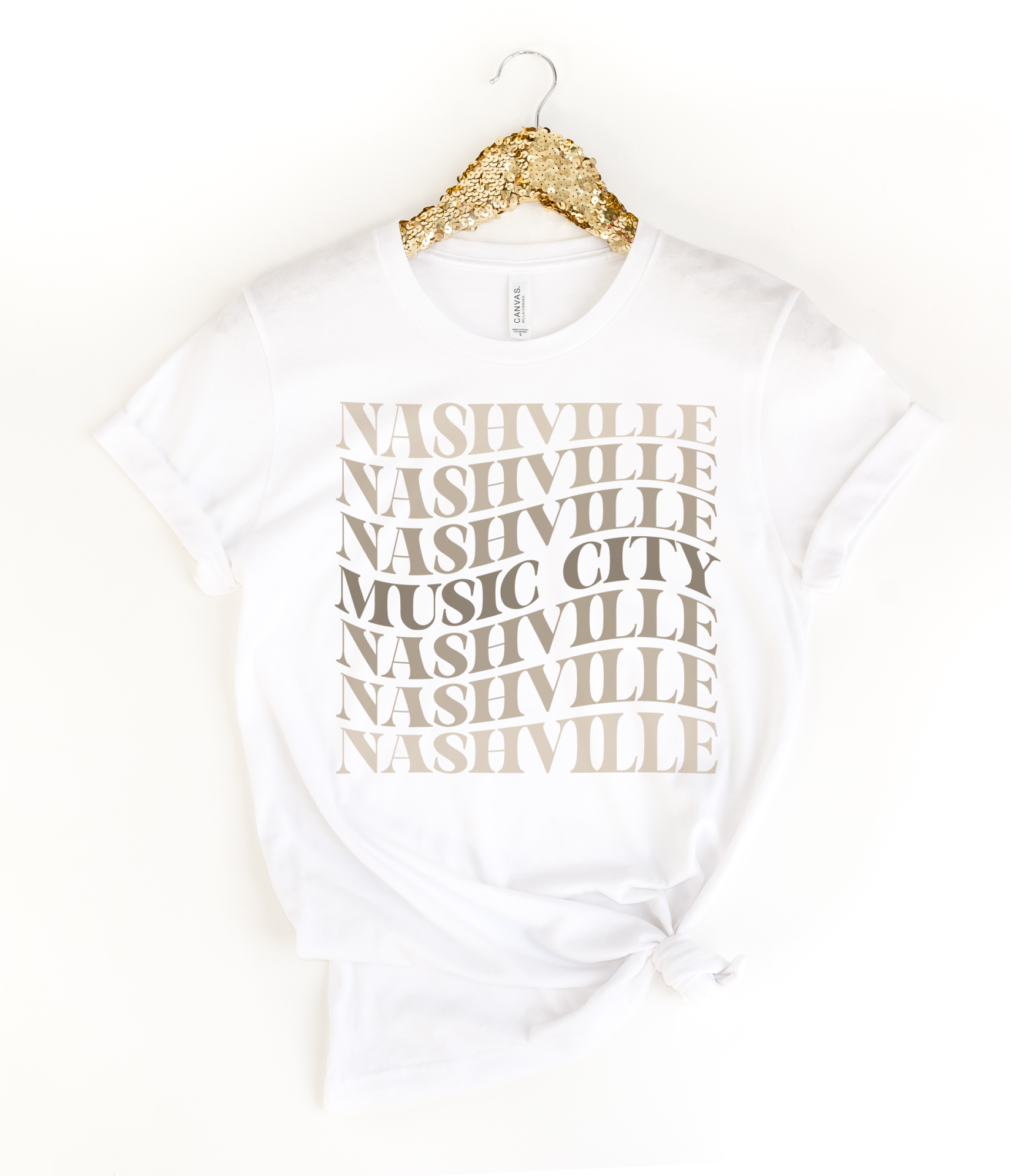  White tee with stacked “Nashville Music City” design in neutral tones. 
