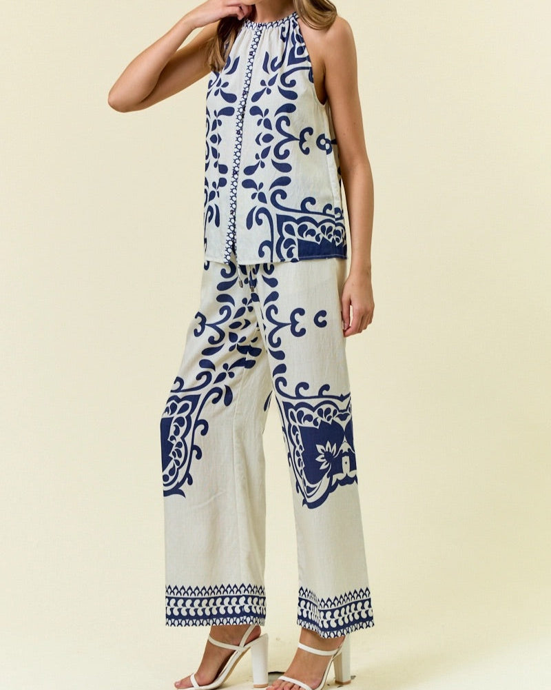 Navy and ivory halter-style sleeveless top with bold ornamental print.