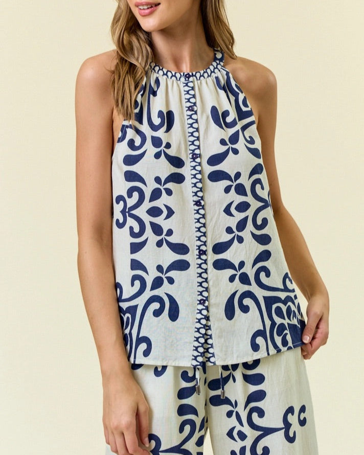 Navy and ivory halter-style sleeveless top with bold ornamental print.