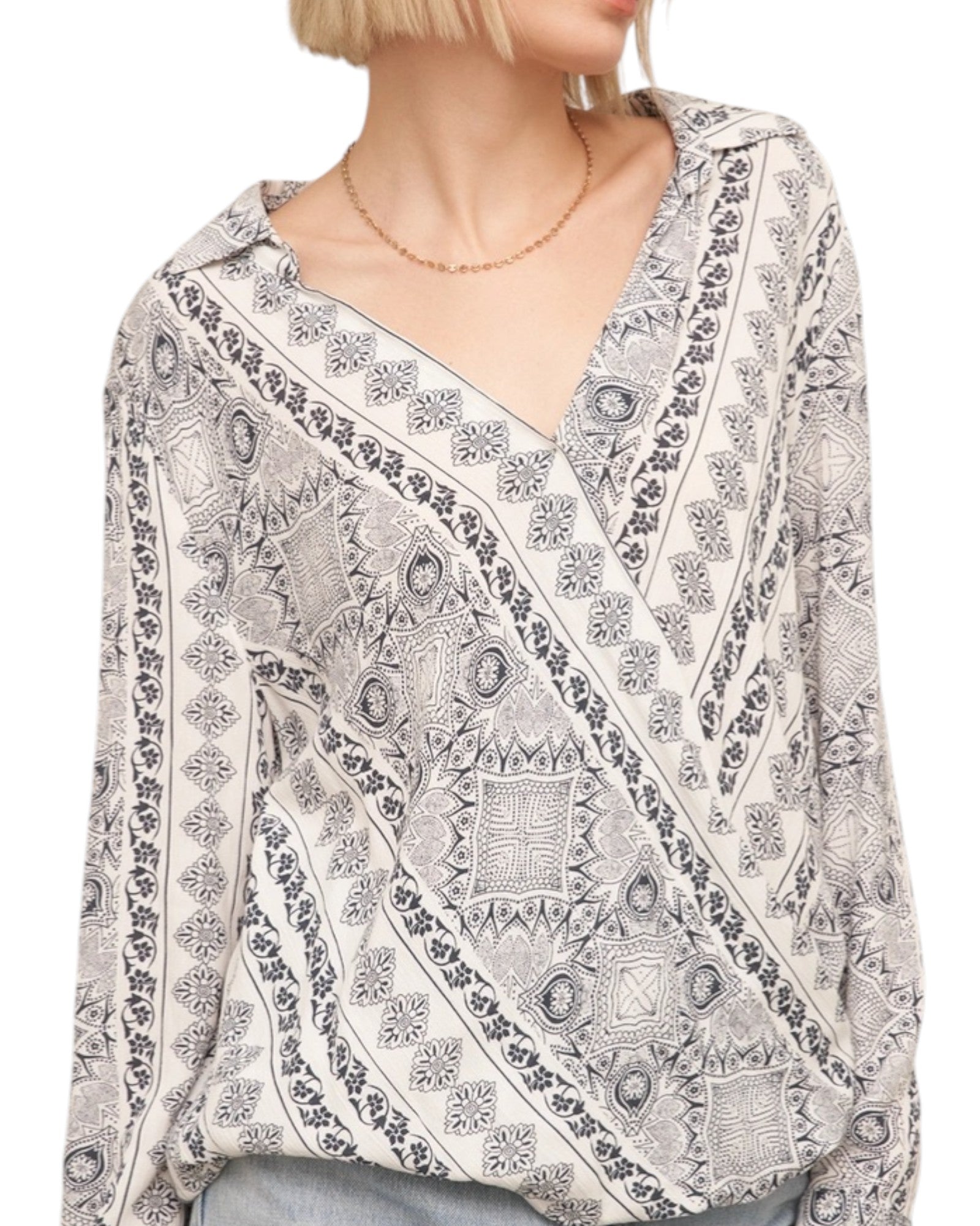 Woman wearing a patterned blouse with a white background.