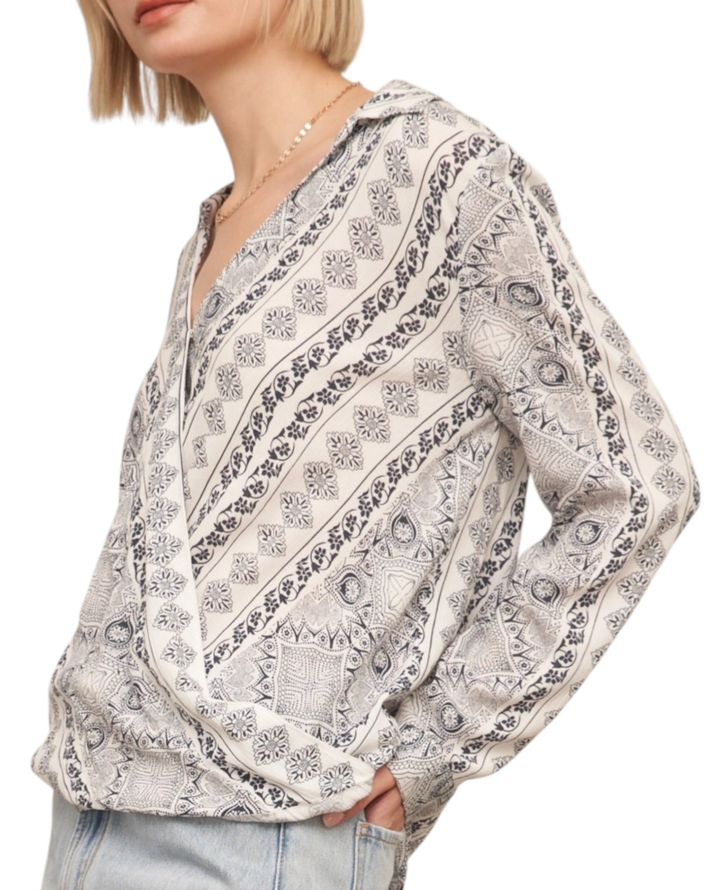 Woman wearing a patterned blouse with a white background.