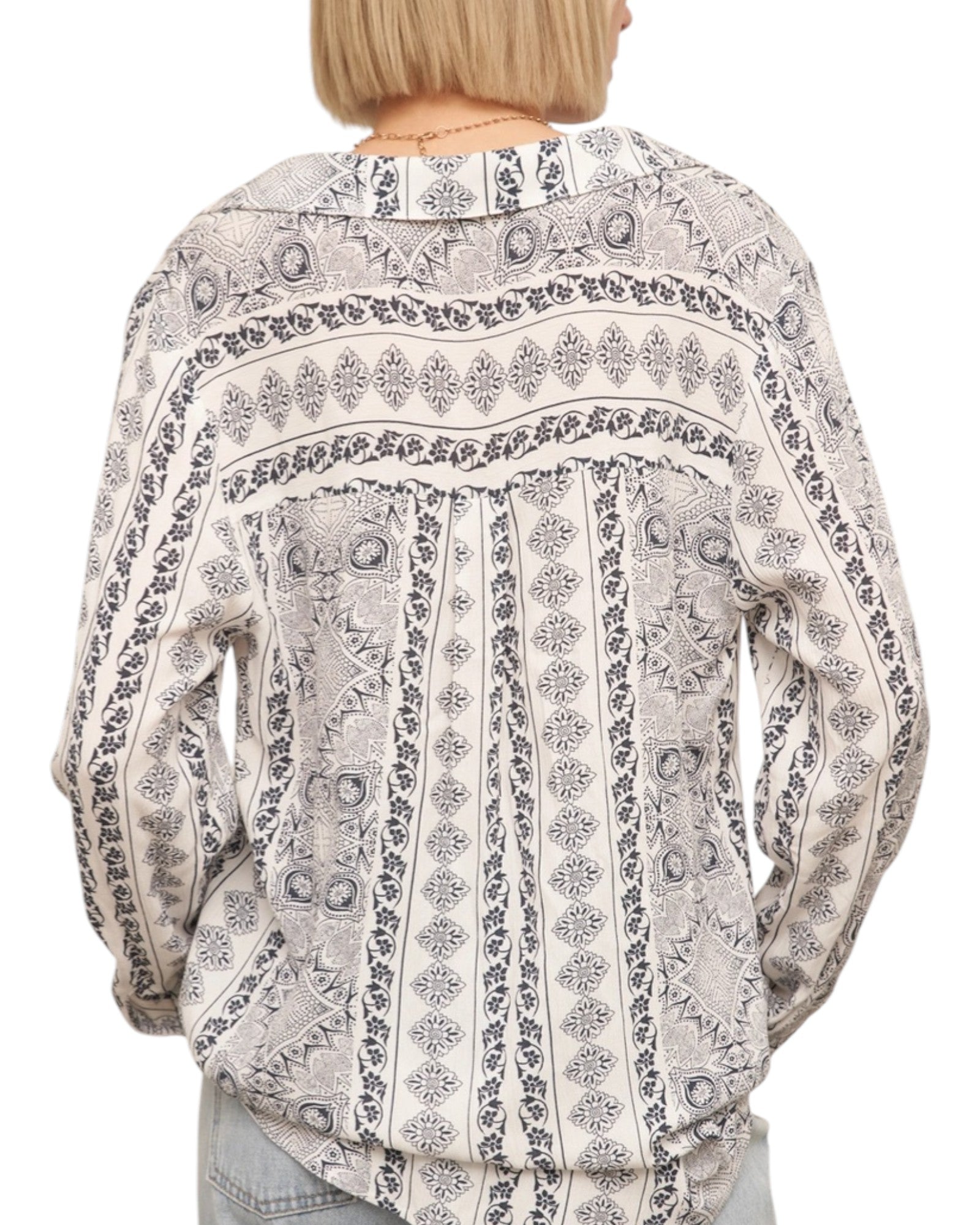 Patterned blouse worn by a person on a white background.