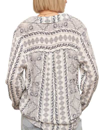 Patterned blouse worn by a person on a white background.