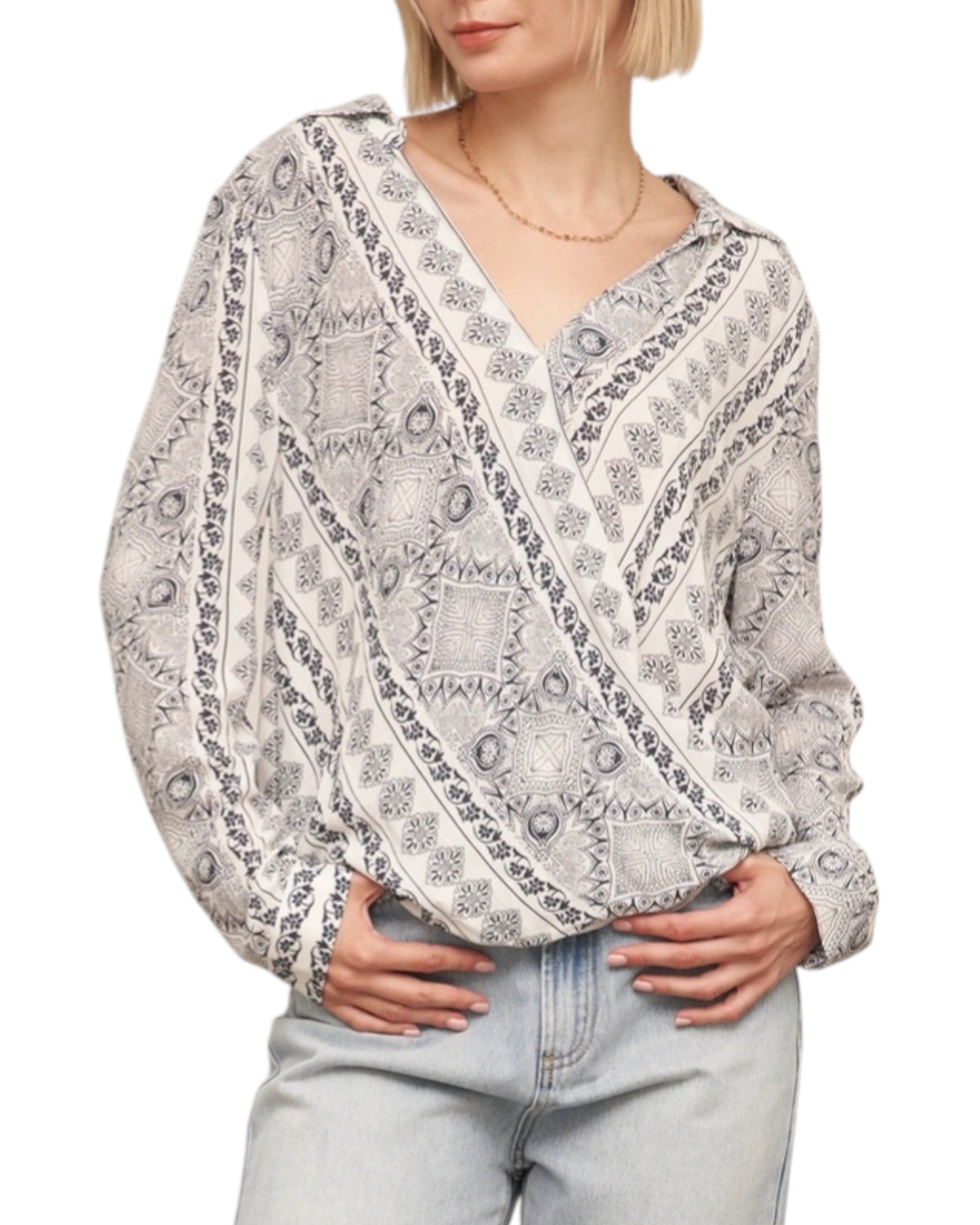 Woman wearing a patterned blouse with long sleeves on a white background.