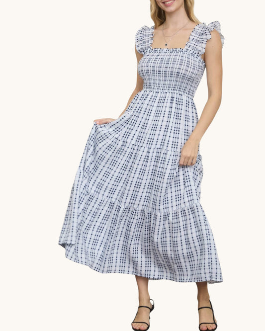 Woman wearing a blue and white checkered dress on a white background.