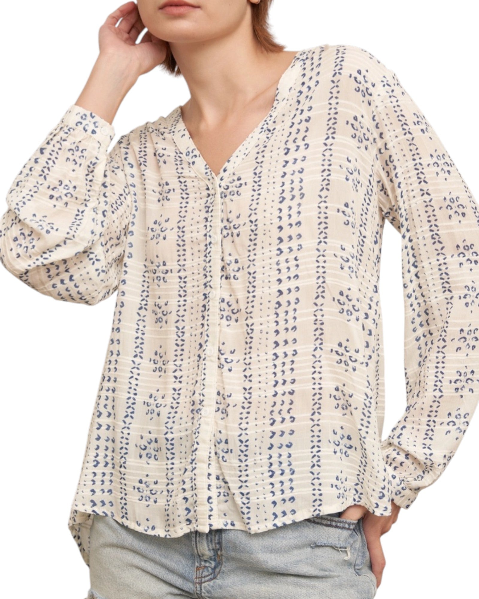 Woman wearing a textured ivory blouse with blue print and denim shorts on a white background.