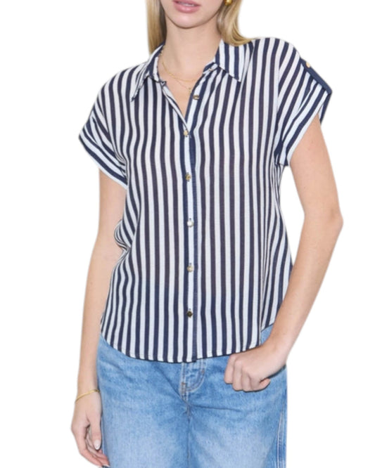 Woman wearing a navy and white striped shirt with short sleeves on a white background.