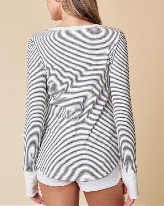  Off white and black striped Henley top with snap button neckline and soft ribbed texture. 