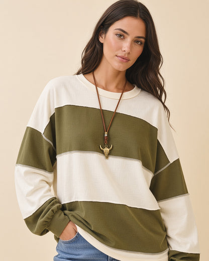 Model wearing a relaxed fit long sleeve top with crew neck, wide olive and butter color blocks and exposed seams.