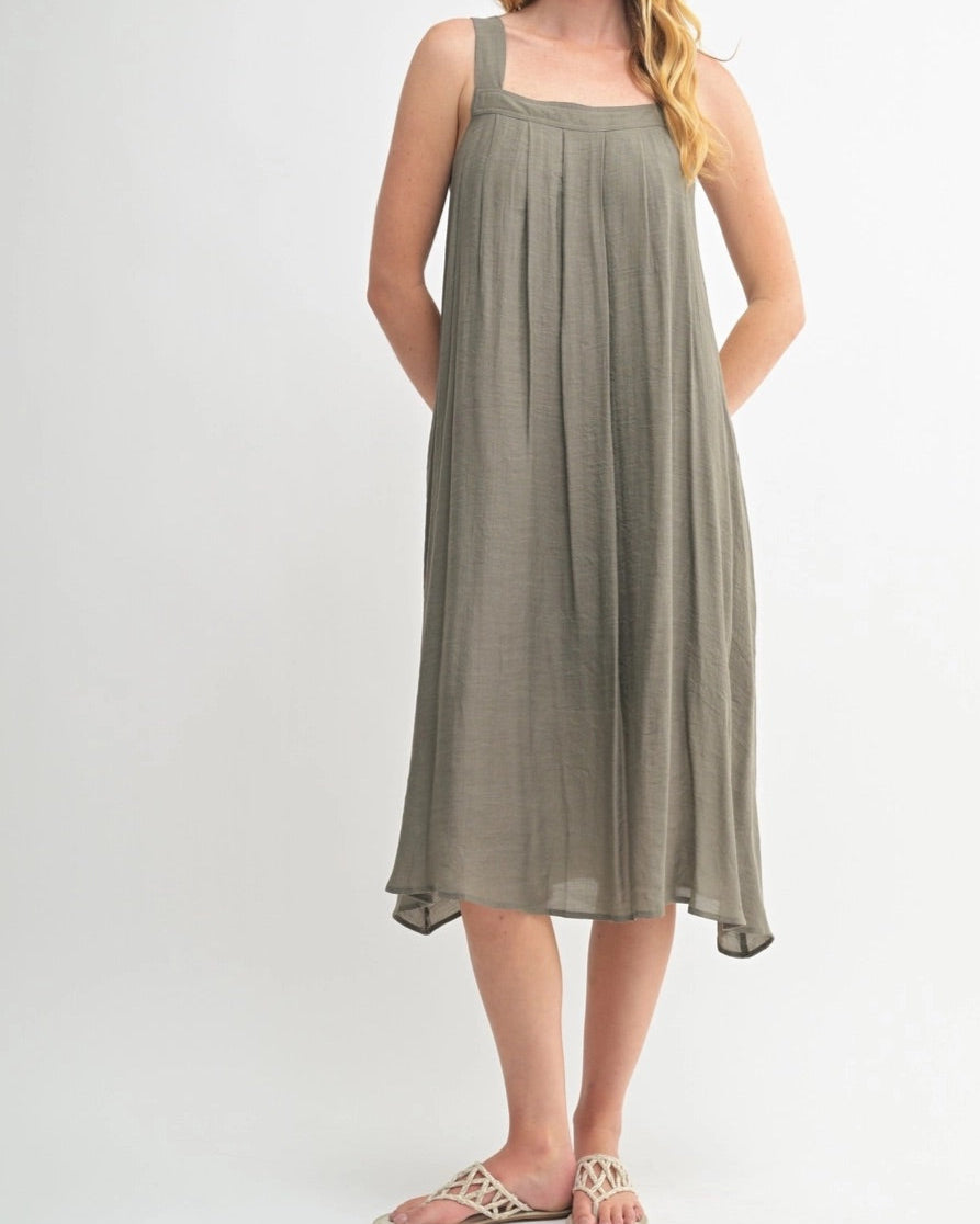 Woman wearing an Olive Green square neck midi dress with wide straps and pleats.
