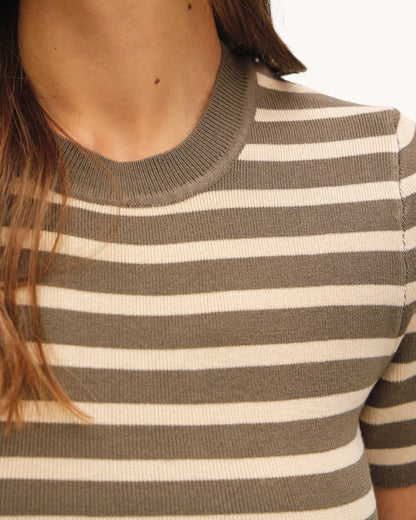 Close-up of a person wearing a olive/brown and ivory striped sweater top.