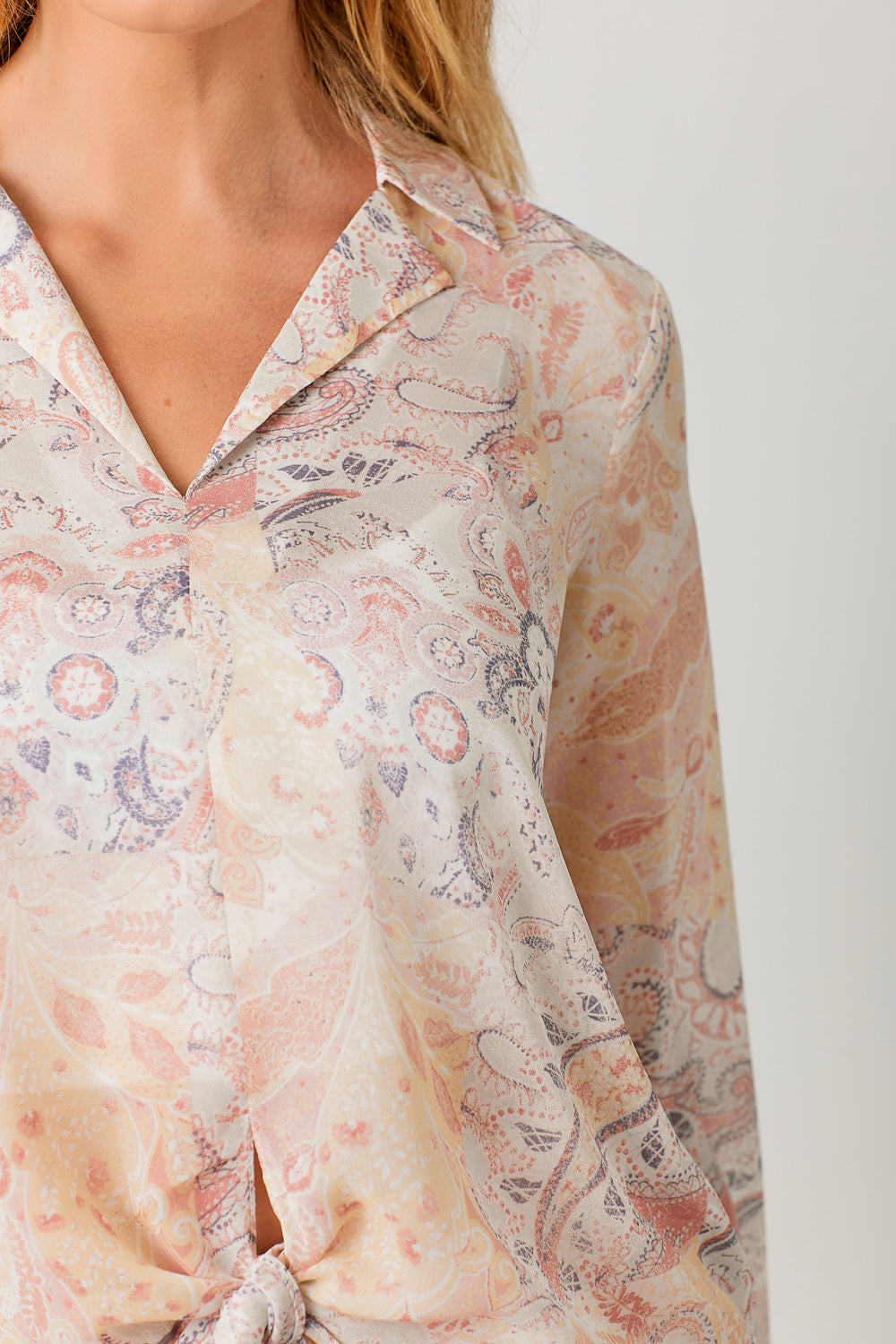 Semi-sheer pastel paisley tie-front blouse with V-neck and hi-lo hem.