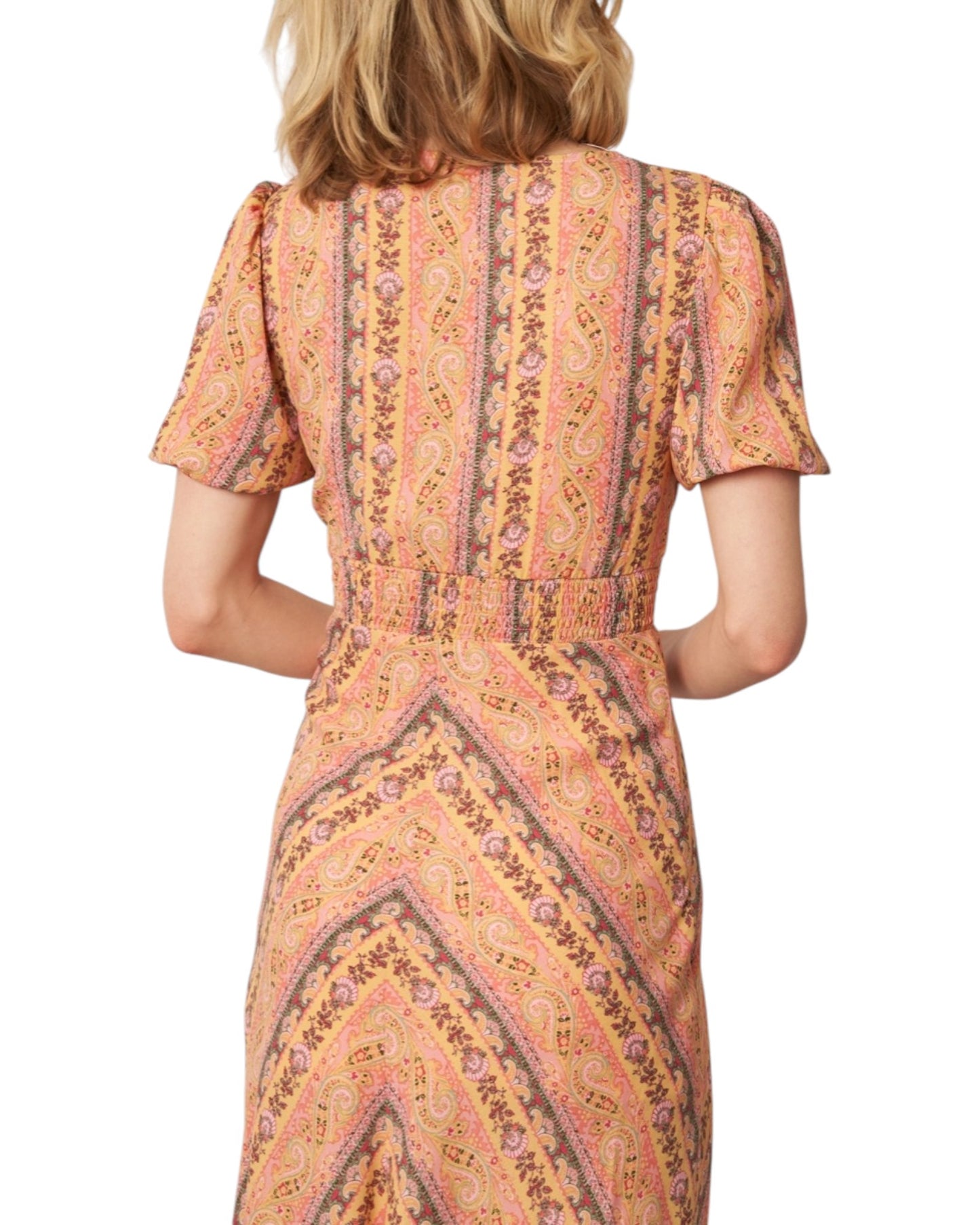 Woman wearing a patterned dress on a white background.