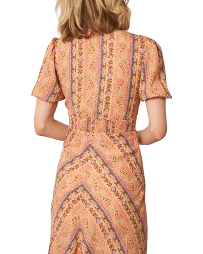 Woman wearing a patterned dress on a white background.