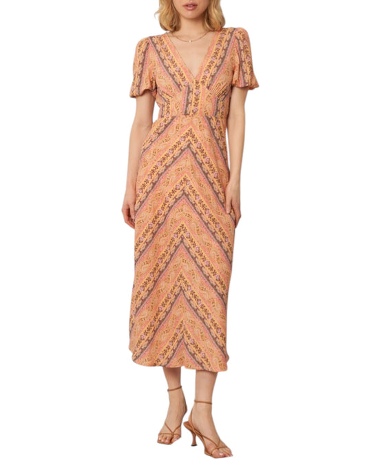 Woman wearing a soft pink paisley patterned midi dress on a white background.