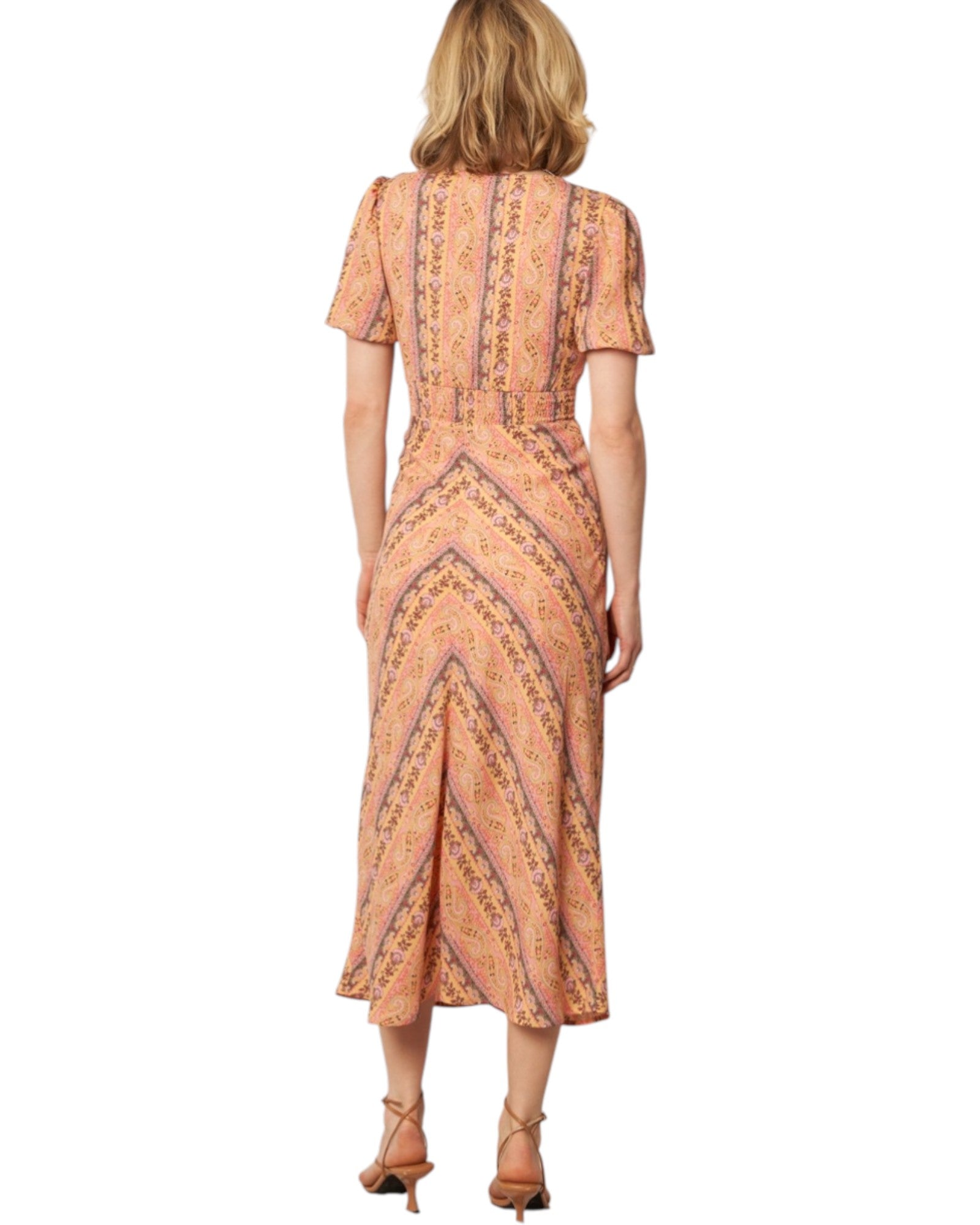 Woman wearing a patterned dress on a white background.
