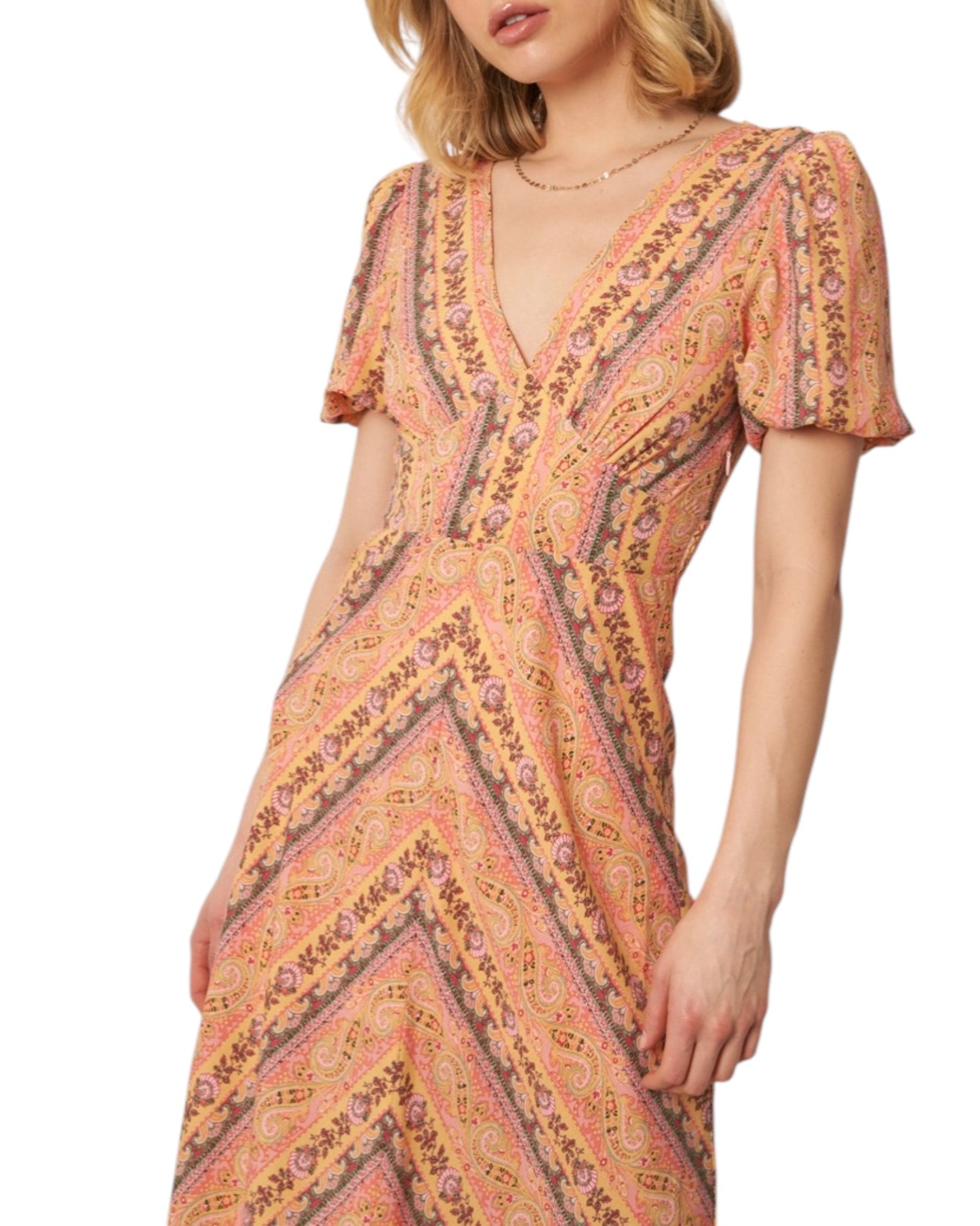 Woman wearing a soft pink paisley patterned midi dress on a white background.