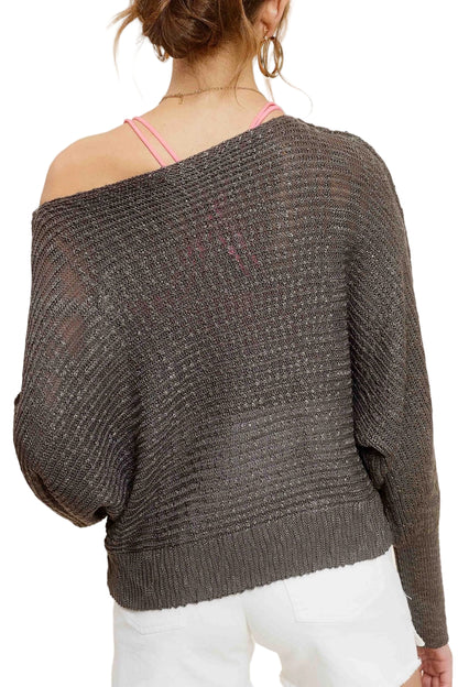 Woman wearing Pebble/Grey lightweight dolman sleeve boat neck sweater with exposed seams.