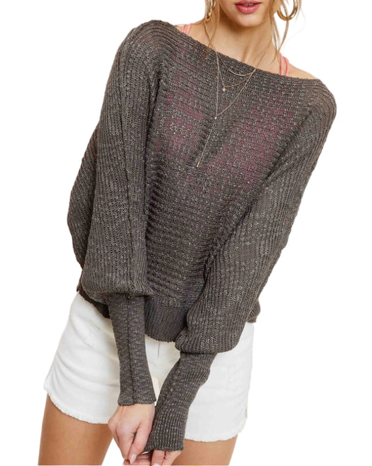 Woman wearing Pebble/Grey lightweight dolman sleeve boat neck sweater with exposed seams.