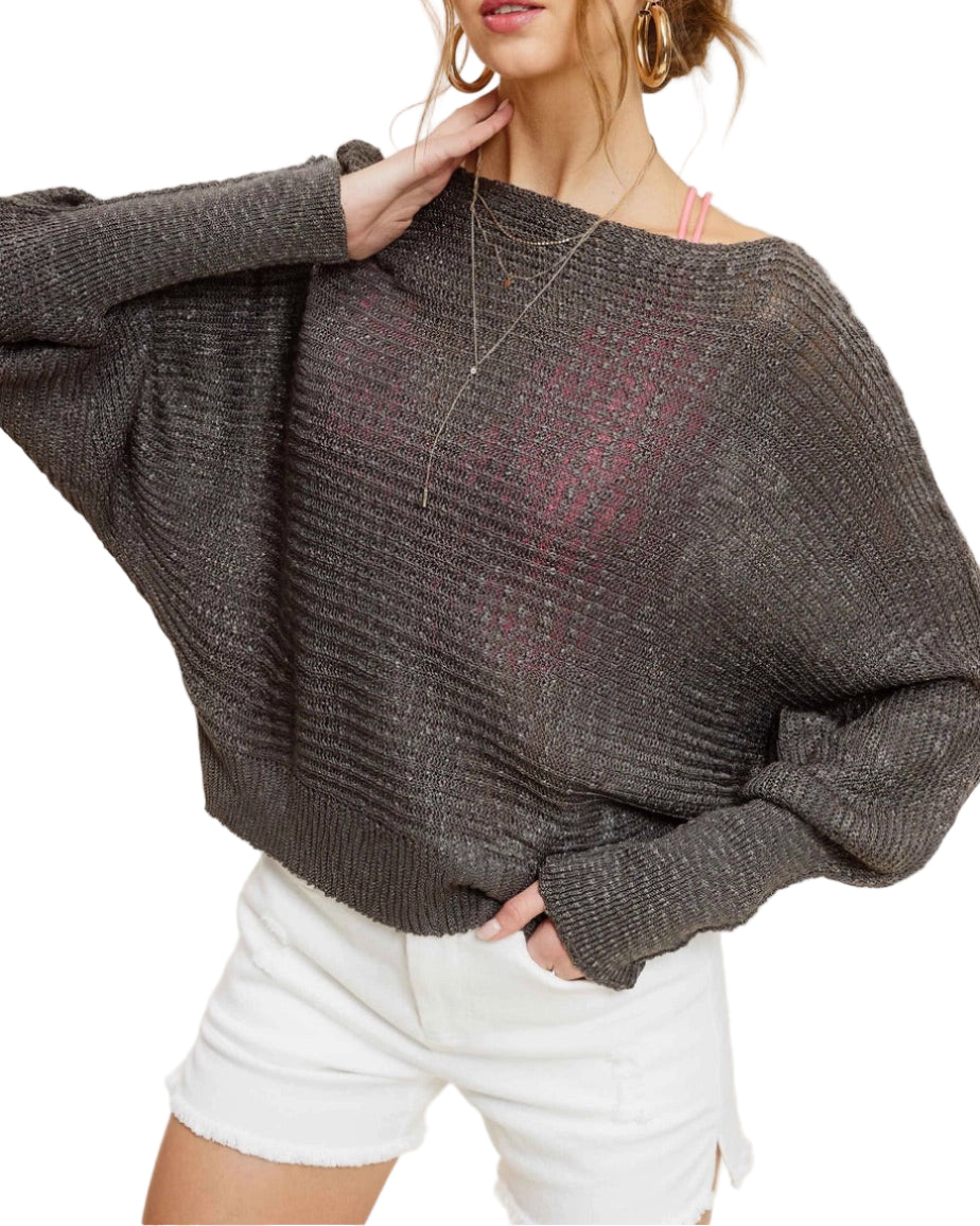 Woman wearing Pebble/Grey lightweight dolman sleeve boat neck sweater with exposed seams.