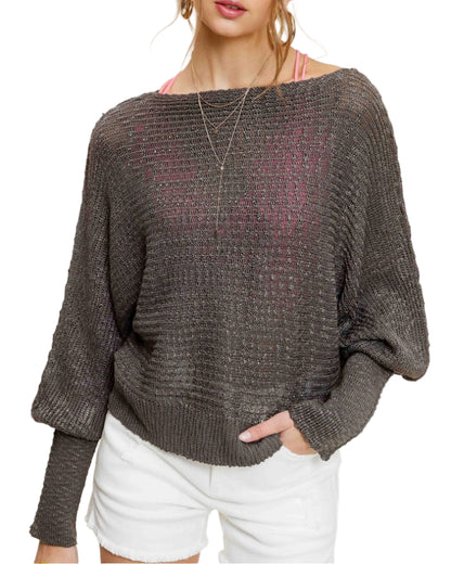 Woman wearing Pebble/Grey lightweight dolman sleeve boat neck sweater with exposed seams.