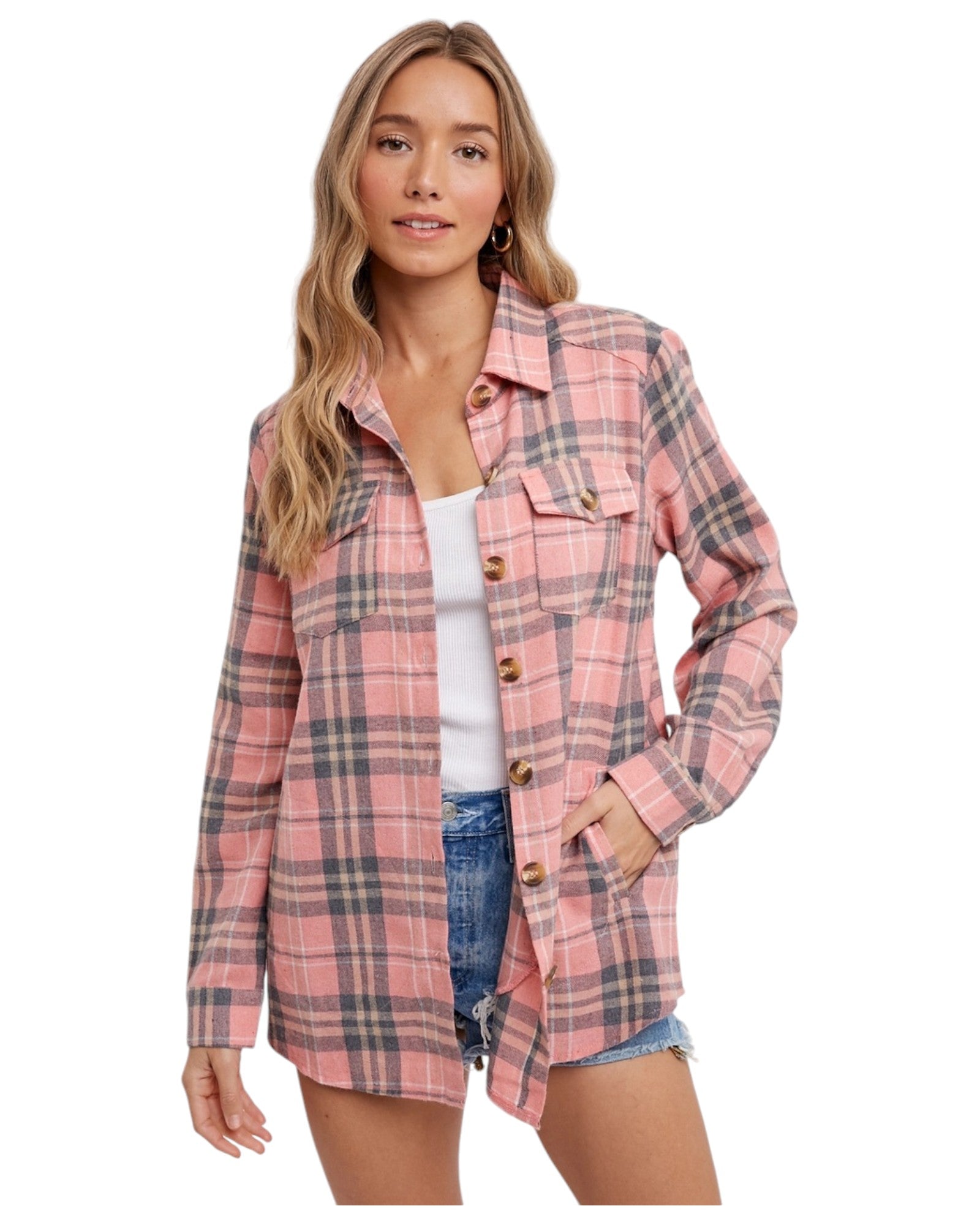 Woman wearing a pink long sleeve plaid flannel top and white tank top. 