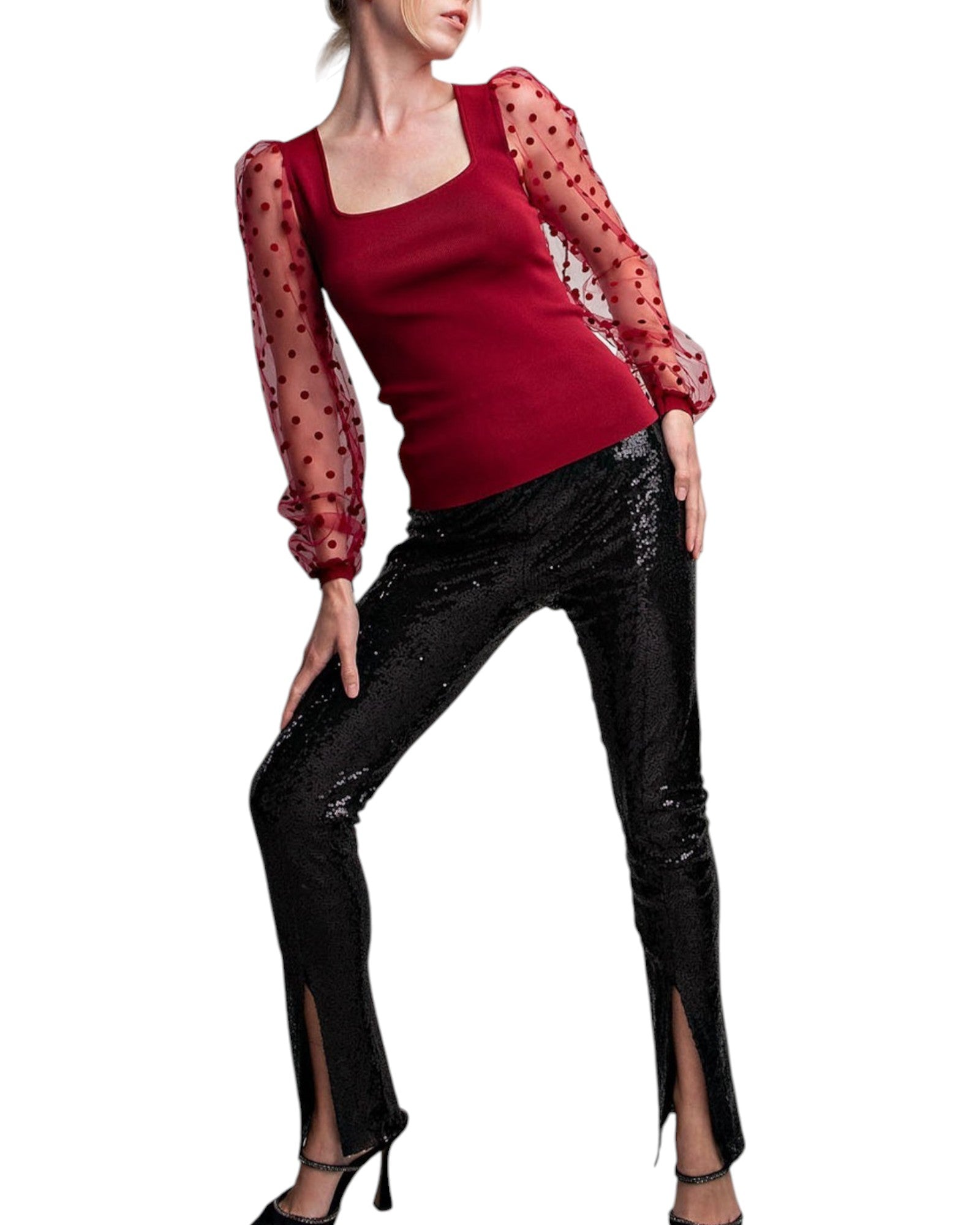 Woman wearing a merlot colored top with long, sheer sleeves with velvet polka dots. 