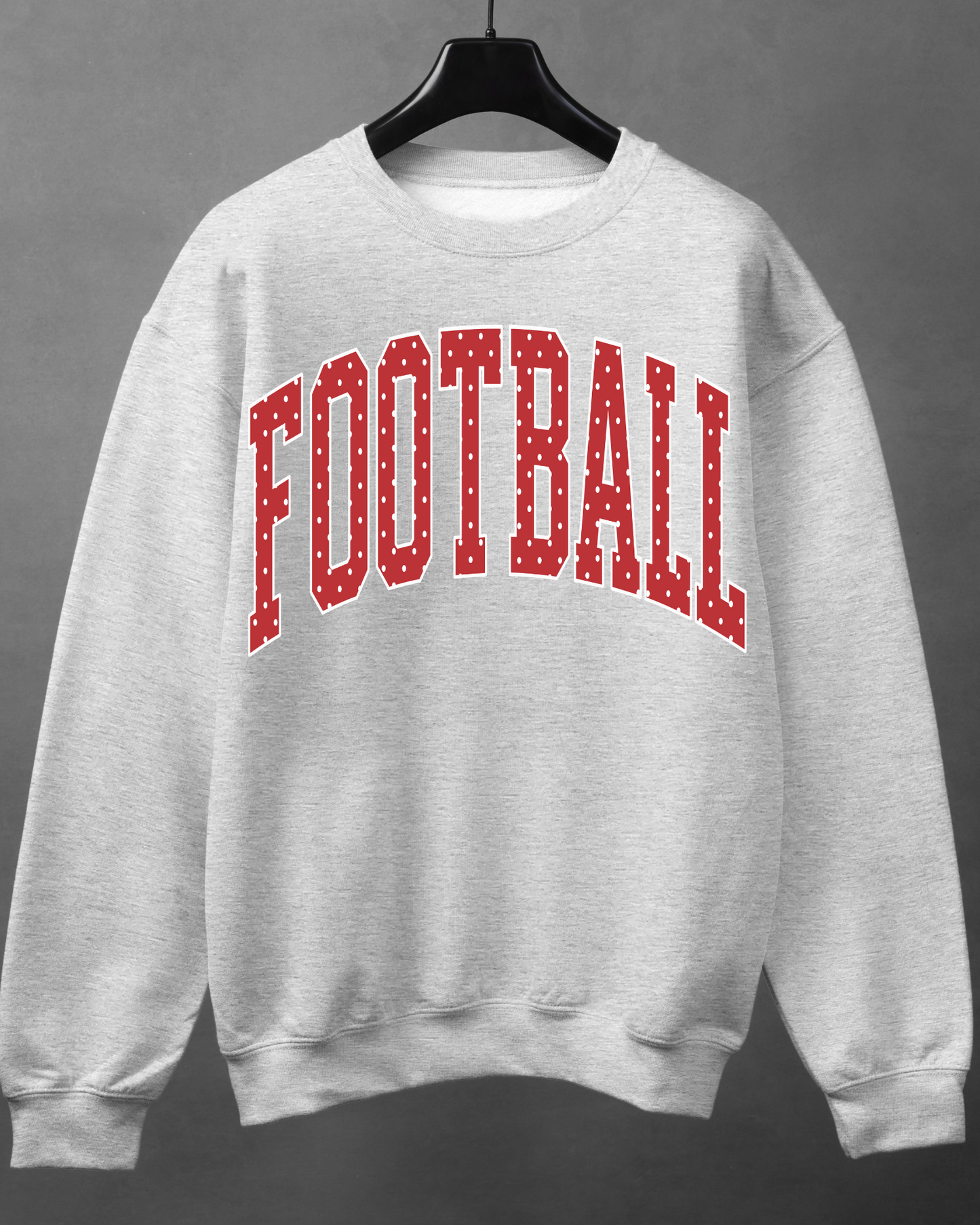 Light heather gray crewneck sweatshirt with red varsity-style FOOTBALL lettering and white polka dots.