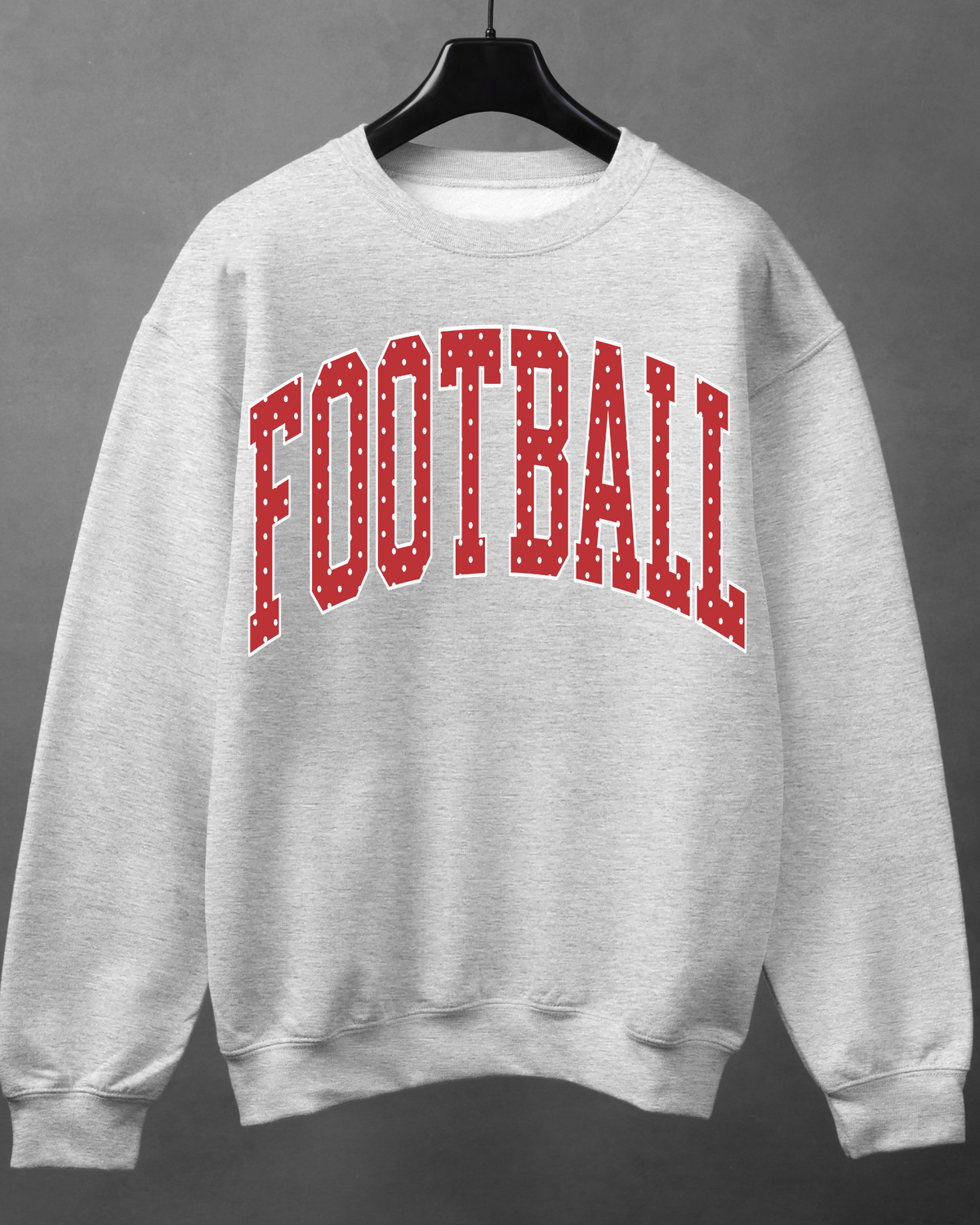 Light heather gray crewneck sweatshirt with red varsity-style FOOTBALL lettering and white polka dots.