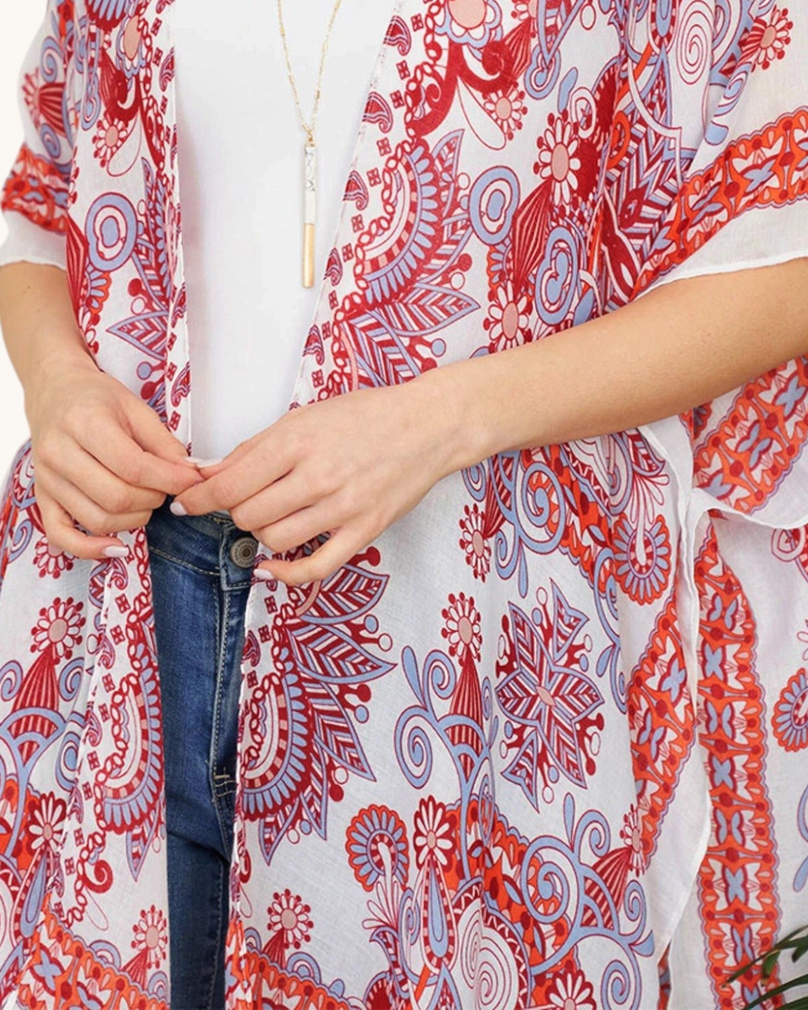 Close up of a person wearing a red and white patterned open wrap style top.