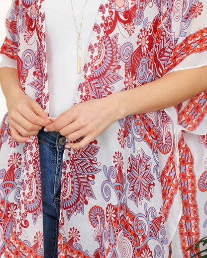 Close up of a person wearing a red and white patterned open wrap style top.