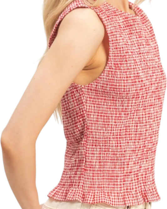 Red and white checkered sleeveless top worn by a person on a white background