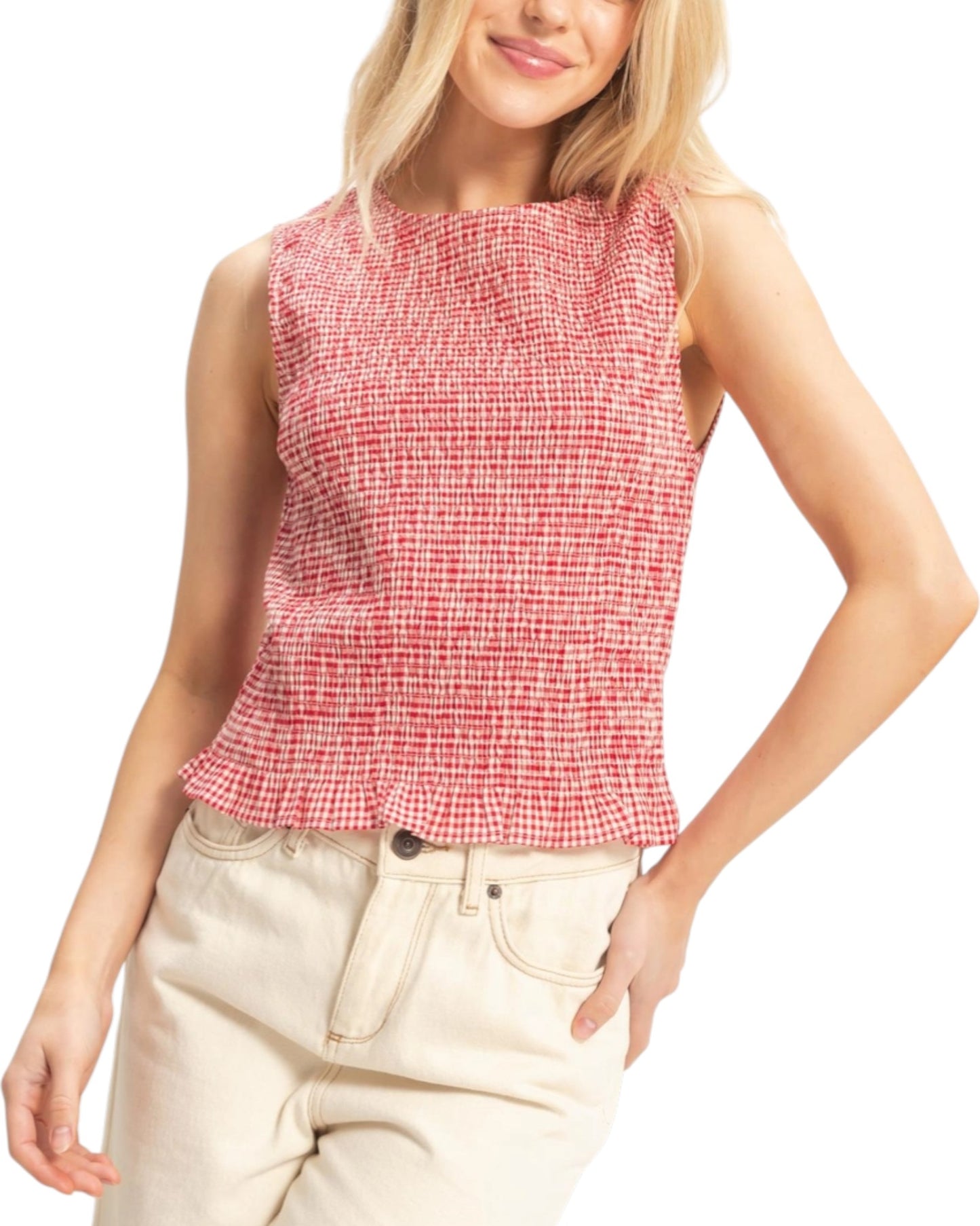 Woman wearing a red checkered sleeveless top and beige pants on a white background.