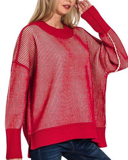 Woman wearing a red striped sweater and blue jeans on a white background.
