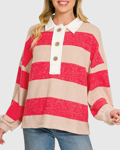 A woman wearing a long-sleeve knit polo shirt with bold horizontal stripes in bright red and warm beige, featuring a white collar and a three-button placket.