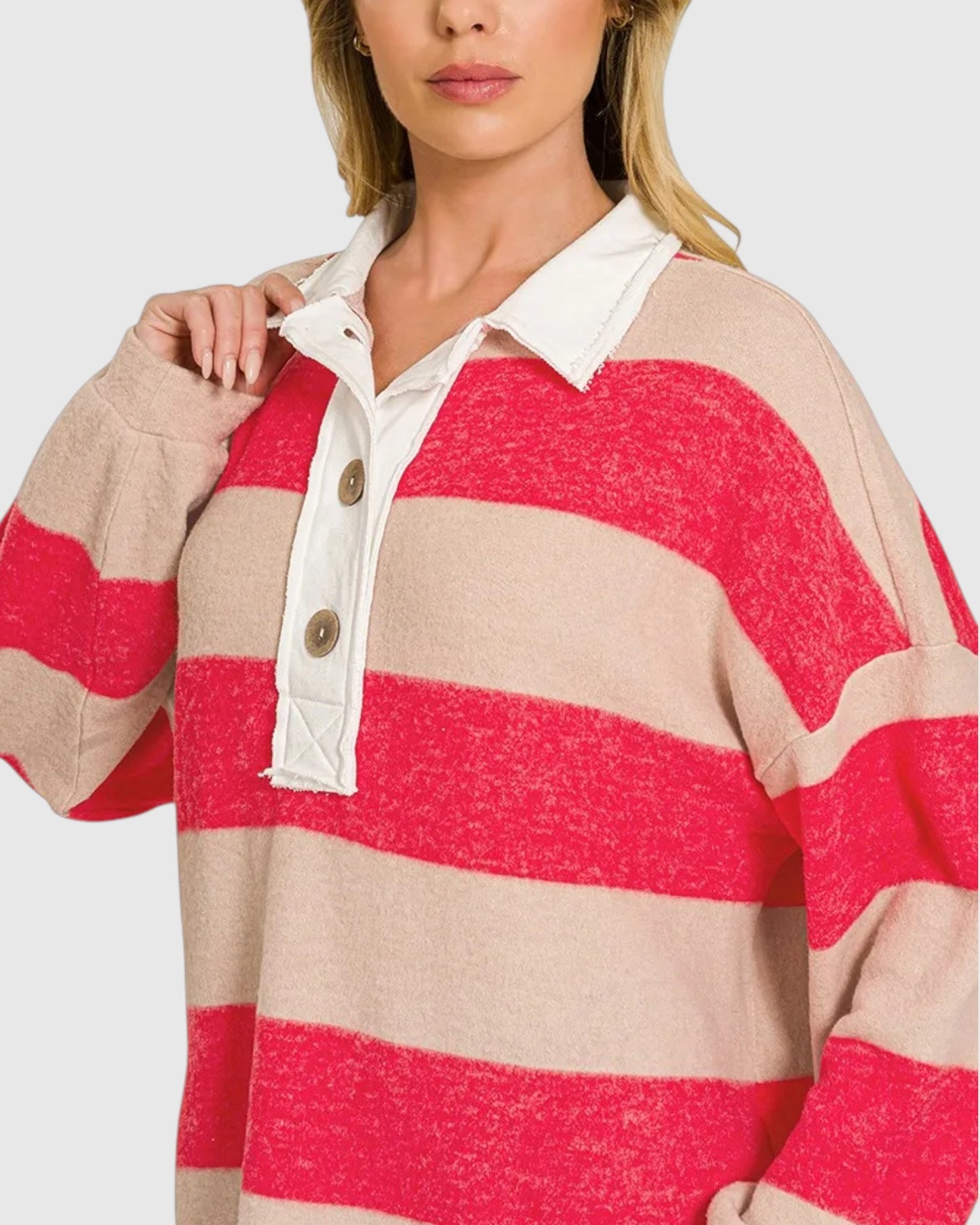 Woman wearing a ruby red and beige long sleeve polo shirt with contrasting cream placket.