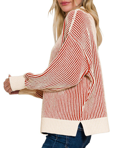 Woman wearing a red and ivory striped sweater with a plain background.