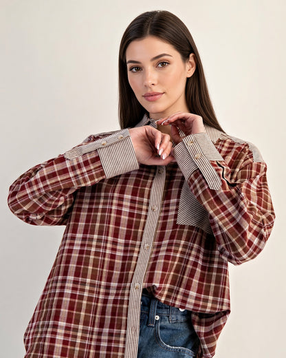 Front detail of rust plaid cotton shirt with striped placket, chest pocket, and button cuffs.