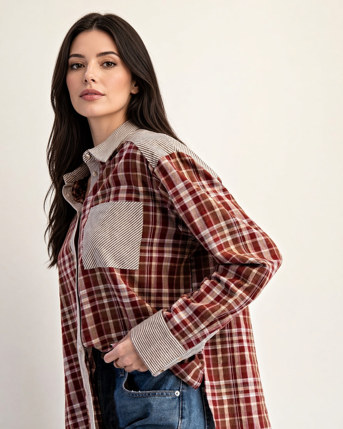 Model wearing rust plaid button-up, showing striped collar, chest pocket, and cuff details.