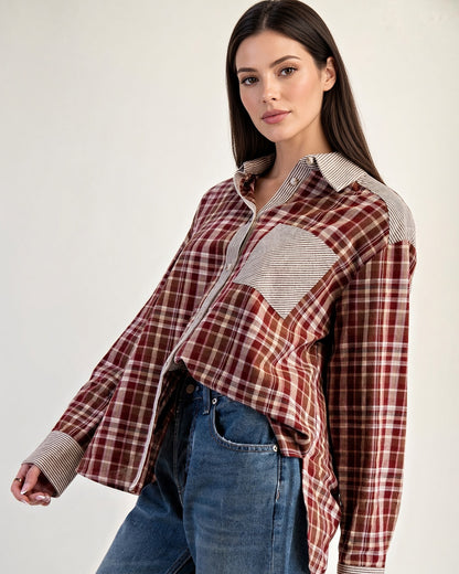 Angled front view of rust plaid cotton button-up with contrasting striped trim and long sleeves.