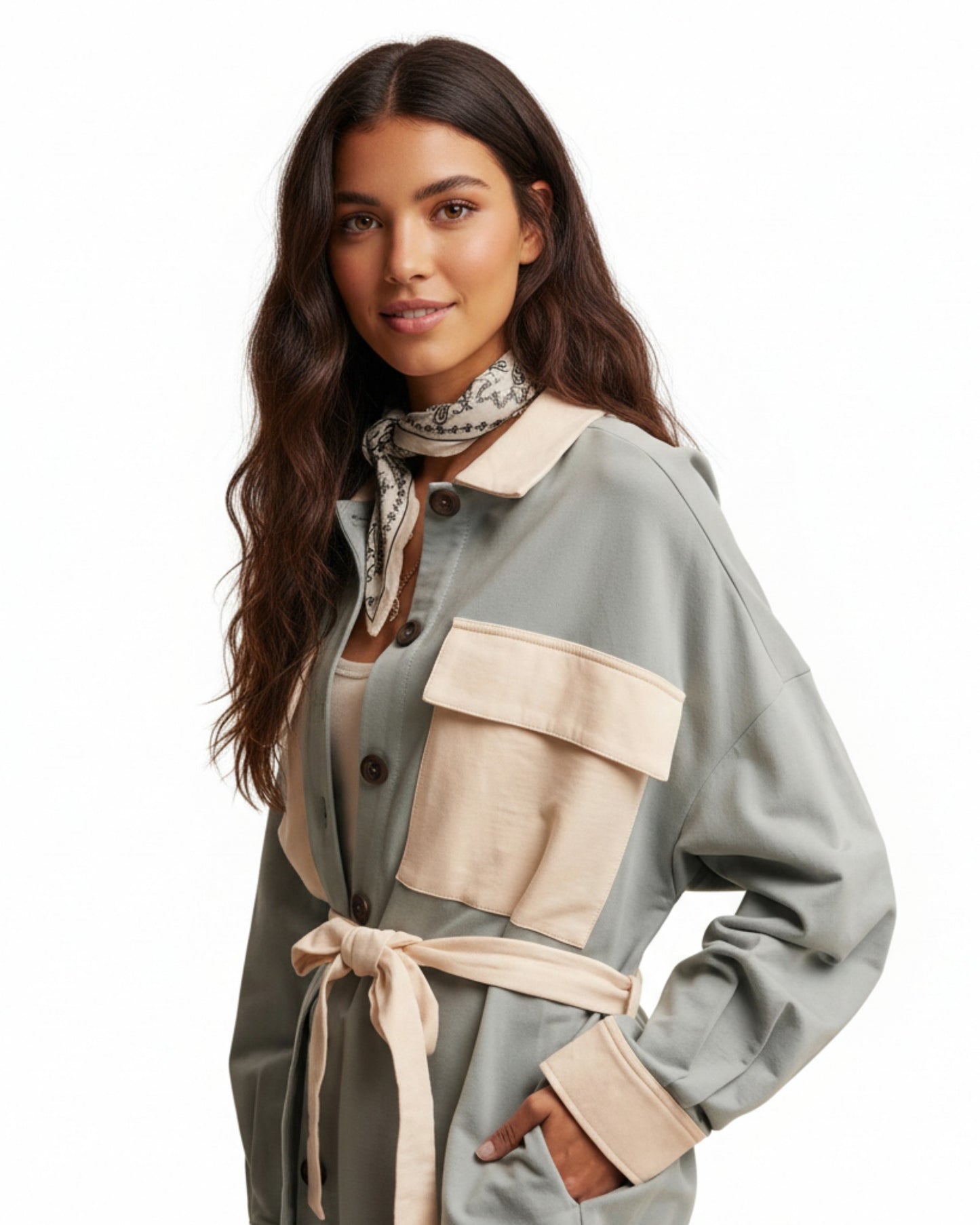 Woman wearing a light sage jacket with ivory accents on a white background.