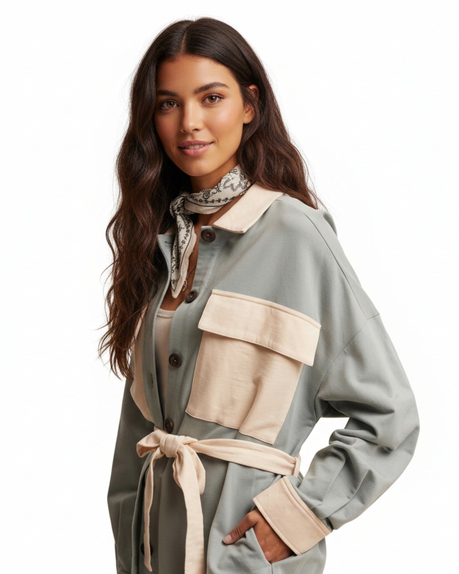 Woman wearing a light sage jacket with ivory accents on a white background.