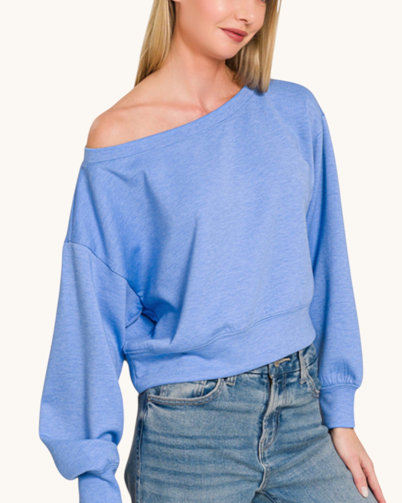 Blue off-shoulder cropped scuba sweatshirt worn by a person on a white background.
