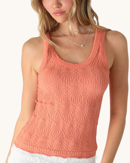 Woman wearing a coral tank top on a white background.