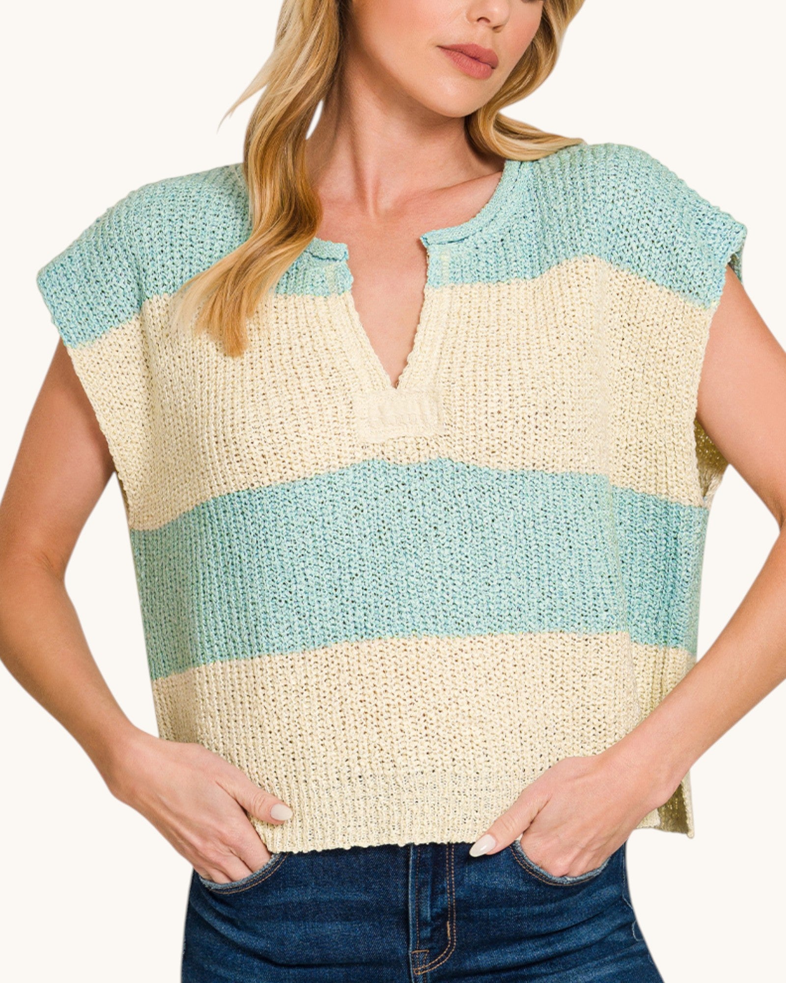 Woman wearing a sleeveless, striped top with blue and beige colors on a white background.