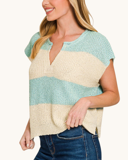 Woman wearing a two-tone sweater with blue and beige colors on a white background.