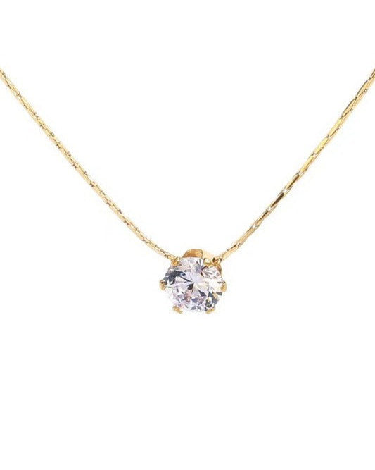 Gold necklace with a clear gemstone pendant on a white background